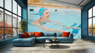 Swimming, physiotherapy and exercise with a senior woman in water for rehabilitation or recovery. Fitness, pool and health with a mature female being active during a swim in the gym for wellness Wall mural