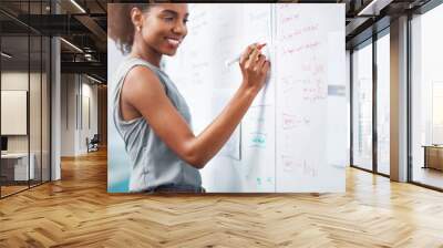 African businesswoman and project manager planning a marketing strategy and brainstorming ideas on a whiteboard for her presentation. Black entrepreneur creating schedule and plan for success Wall mural