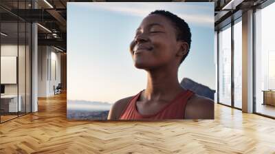 Fitness, calm and breathing of black woman outdoor in nature, mountains and blue sky background for yoga wellness, meditation and zen energy. Face of girl breathing for peace, freedom and mindfulness Wall mural