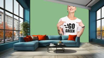 Mockup, sustainable fashion and green background, woman with tshirt and space for eco friendly product placement. Sustainability, fashion and climate change influencer with smile and cotton clothes. Wall mural