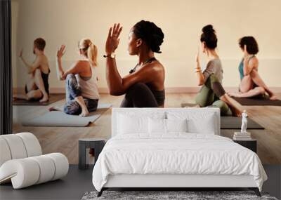 On the mat youll find out what truly matters. Shot of a group of young men and women practicing yoga in a fitness class. Wall mural