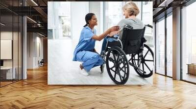 She doesnt just see the patient, she sees the person. Shot of a young nurse caring for a senior woman in a wheelchair. Wall mural