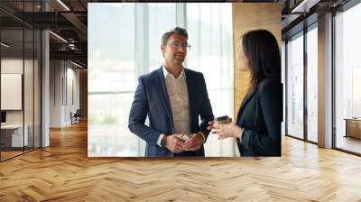 Hes always interested in what she has to say. Shot of two businesspeople talking in a corporate office. Wall mural