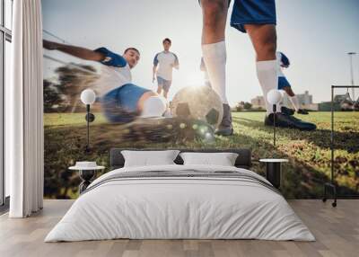 Closeup, ball and soccer with men, tackle and exercise with sports, competition and training. Zoom, football and healthy athletes with energy, fitness and teamwork for a match, action and blur motion Wall mural