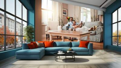 Senior couple, sofa and relax with watching tv, phone and social media with hug, care and bonding in home. Mature man, woman and happy together on living room couch with movie, web chat and embrace Wall mural