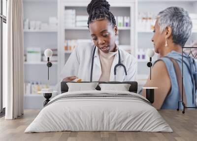 Black woman, doctor and prescription medication for patient or over the counter pills at pharmacy. African medical pharmacist consulting senior client for dosage, symptoms or side effects at clinic Wall mural