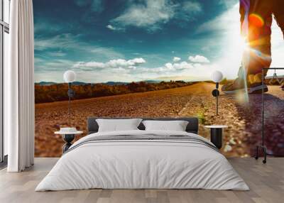 Travel man tourist alone on the road and sunset desert landscape.Adventur lifestyle and extreme travel road vacations Wall mural