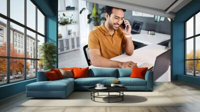 Phone call, smile and strategy with a business man chatting while working at his desk in the office. Mobile, contact and communication with a young male employee chatting or networking for planning Wall mural