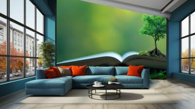 Open book with small tree growing on it, nature education concept Wall mural