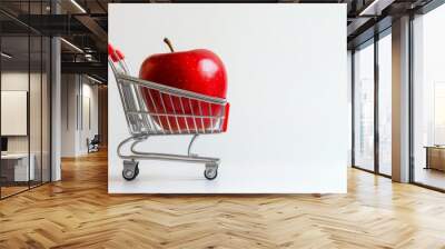 Red apple in a miniature shopping cart on white background. Healthy eating and consumerism concept Wall mural