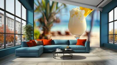 closeup photo of fresh cold alcoholic fruit pina colada cocktail drink glass with cream and pineapple with blurry tropical beach bar in the background Wall mural