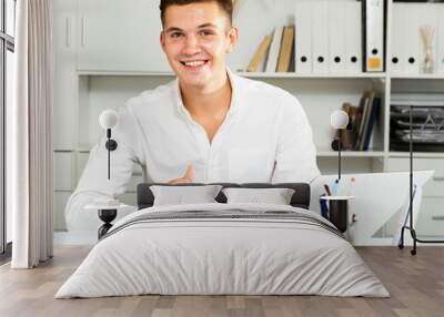 guy in white shirt works in office and smiling Wall mural