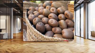 many ripe kiwi in wicker baskets on counter market Wall mural