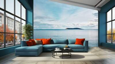 Beautiful minimalist nature background of an island and blue sea at sunrise. Freedom, refreshment, tranquility and adventure holiday. Wall mural