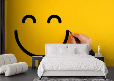 Male hand drawing a smiling happy face sketch on yellow background. Client satisfaction, service or product evaluation Wall mural