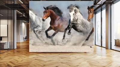 Horses run fast in sand against dramatic sky Wall mural