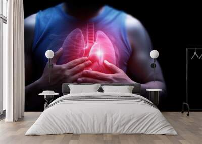 A person holding their chest, symbolizing lung health and respiratory awareness with glowing lungs in focus. Wall mural