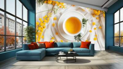 Top view of a cup of tea surrounded by mimosa flowers Wall mural