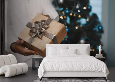 African american black man giving christmas gift in front of the christmas tree. High quality photo Wall mural