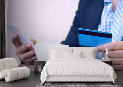 Internet banking, e-commerce and online trading concept. Cropped view of businessman hands holding mobile phone and credit card while paying bill at cafe. Selective focus on man's hands. Wall mural