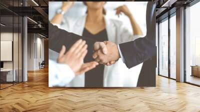 Unknown businesspeople are shaking their hands after signing a contract at meeting, close-up. Business communication concept Wall mural