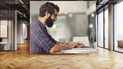 Following my passions while making a great living. Shot of a young designer working on his laptop. Wall mural