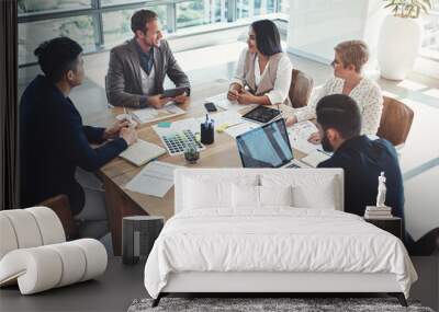 Planning ways to get success within their grasp. Shot of a diverse group of businesspeople having a meeting in an office. Wall mural