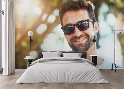 Sunglasses, casual and portrait of a happy man in an outdoor park while on a vacation, adventure or holiday. Smile, confidence and young male person with eyewear standing in a garden on weekend trip. Wall mural