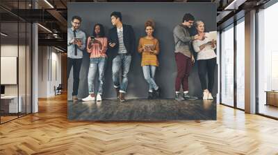 We take every opportunity to social network. Studio shot of a diverse group of creative employees social networking inside. Wall mural