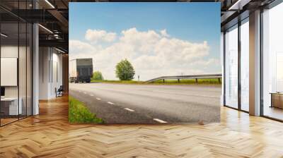 asphalt road on dandelion field with a small truck. lorry moving on sunny evening Wall mural