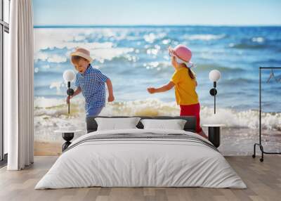 Boy and girl playing on the beach Wall mural