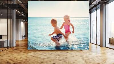 Boy and girl playing on the beach Wall mural