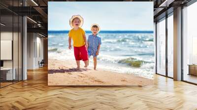 Boy and girl playing on the beach Wall mural