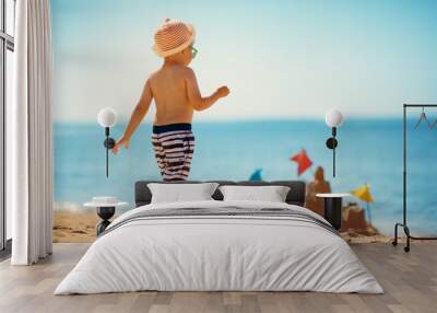 boy sitting smiling at the beach Wall mural