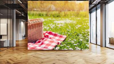 Checkered picnic duvet with empty basket on the blossoming meadow. Wall mural