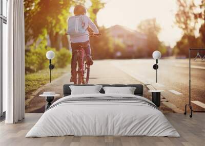 child on a bicycle at asphalt road in early morning. Boy on bike in the city Wall mural