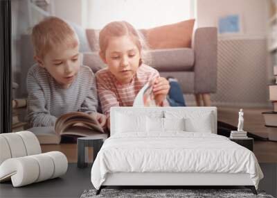 Cute children lying down on the floor and reading books Wall mural