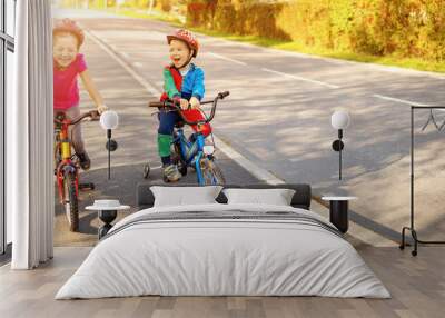 Cute children riding on the bicycles at asphalt road in summer. Wall mural