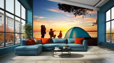 Family resting with tent in nature at sunset Wall mural