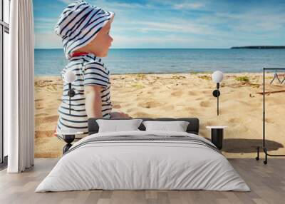 little baby boy sitting on the beach in summer day Wall mural