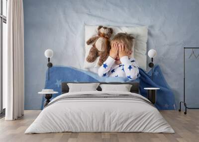 Three years old child crying in bed Wall mural