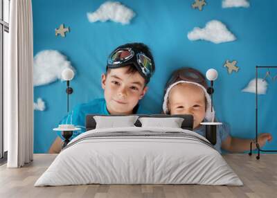 Two boys lying on blanket with white clouds Wall mural