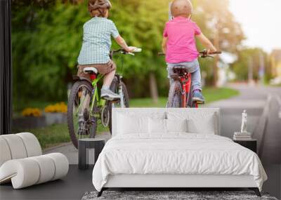 Two boys riding on their bicycles along an asphalt road Wall mural