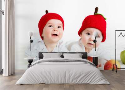 two cute babies lying in hats on soft blanket with apples Wall mural