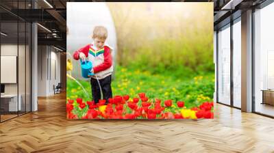 Two cute children watering flowers in the garden Wall mural