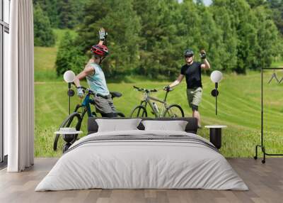 Sport mountain biking couple greeting in meadows Wall mural