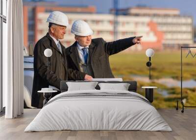 two architects man point at construction site Wall mural