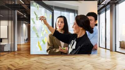 Asian Architects and department manager teamwork meeting discussion and presentation 3D architectural displayed model of energy efficient and sustainability home design in office conference room. Wall mural