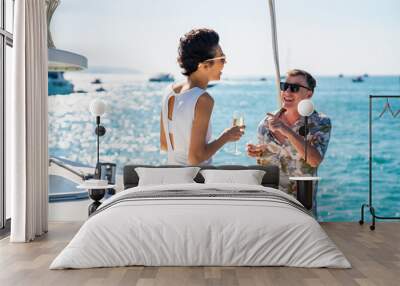 Caucasian couple enjoy outdoor luxury party drinking champagne with talking together while catamaran boat sailing at sunset. Man and woman relax with outdoor lifestyle on summer travel vacation Wall mural