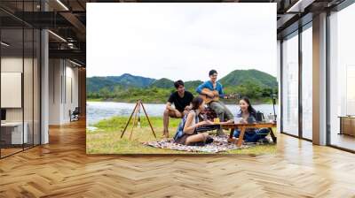 Group of Asian people enjoy and fun outdoor lifestyle hiking and camping together on summer travel vacation. Man and woman friends having breakfast drinking brewed coffee near the tent in the morning. Wall mural